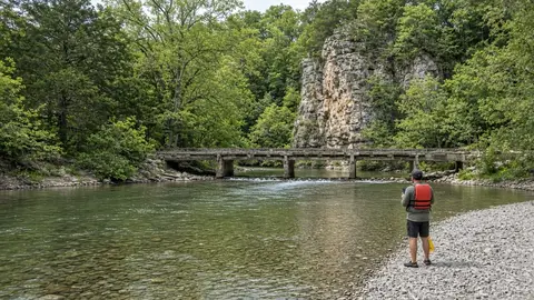 Paddler at a low-water bridge checking the river